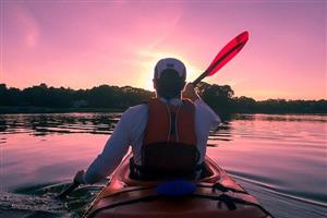 man kayaking at sunset